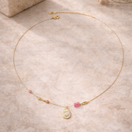 Colgante dorado piedras rosas y detalle de lagrima