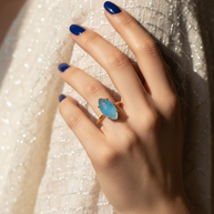 Detalle de la piedra turquesa y acabado dorado del anillo Namare