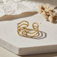 Anillo dorado de líneas onduladas abiertas