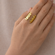 Anillo dorado con diseño en alas abrazadas