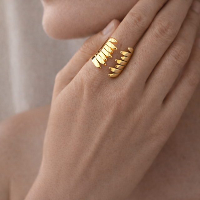 Anillo dorado con diseño en alas abrazadas