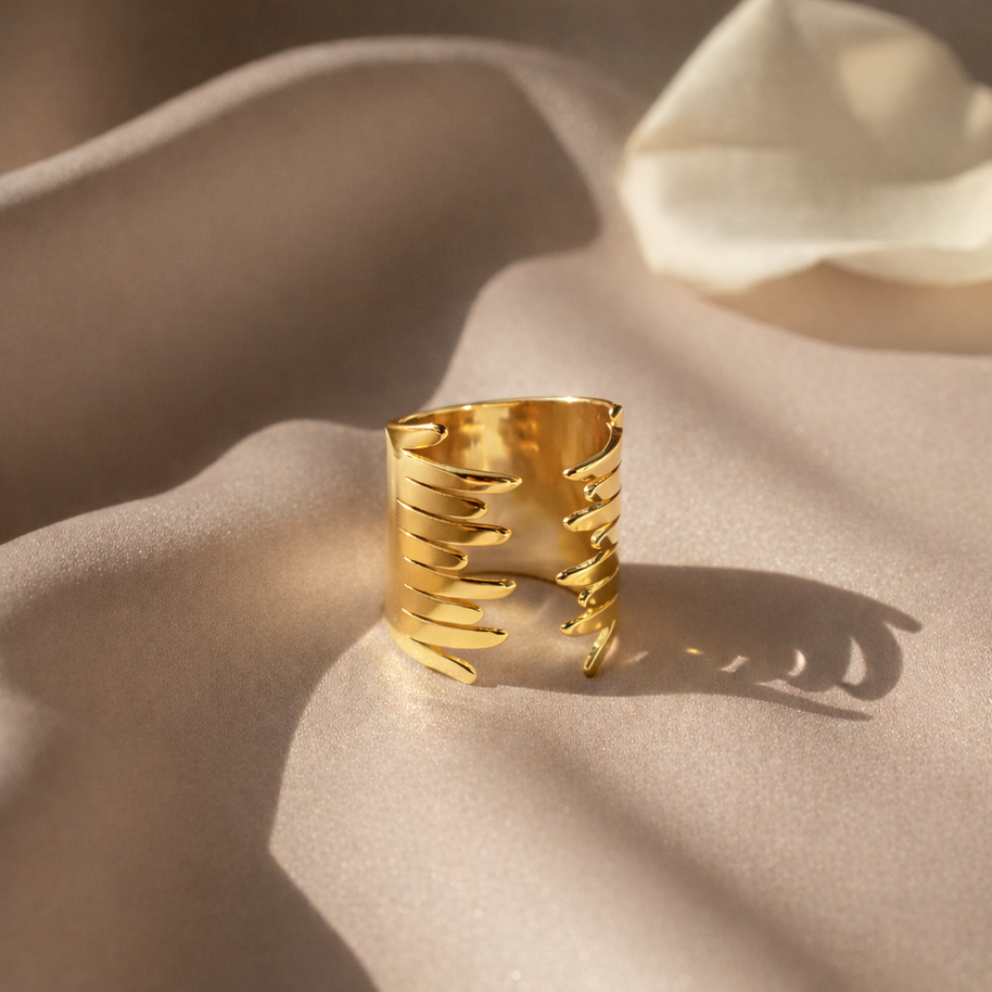 Anillo dorado con diseño en alas abrazadas
