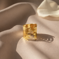 Anillo dorado con diseño en alas abrazadas
