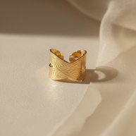 Anillo dorado cruzado con motivos circulares