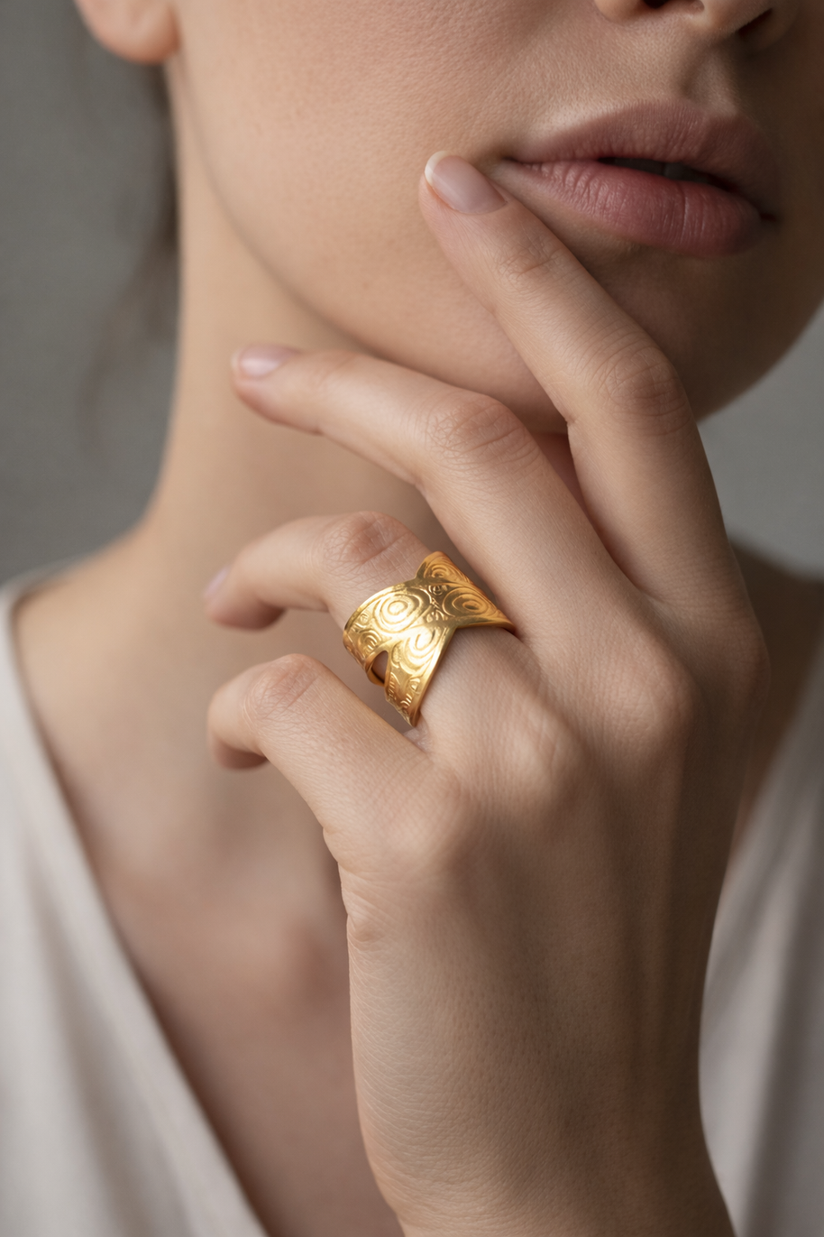 Anillo dorado cruzado con motivos circulares
