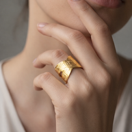 Anillo dorado cruzado con motivos circulares