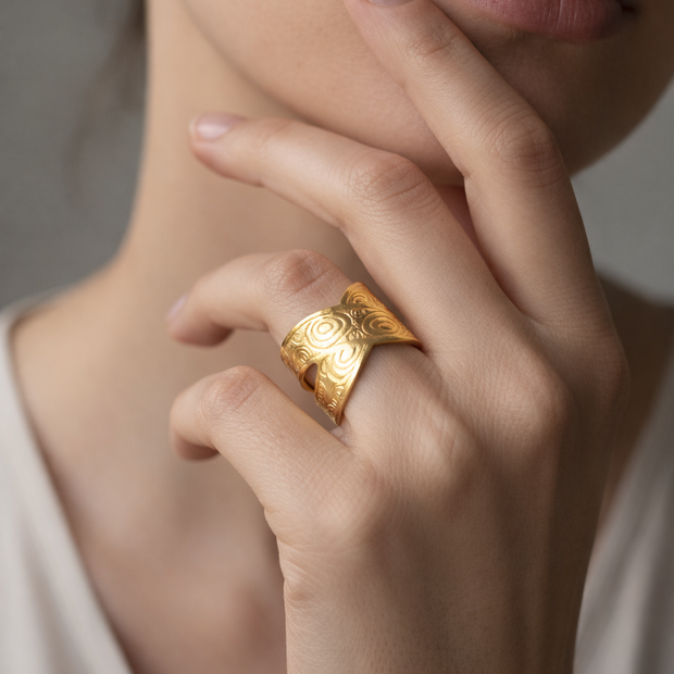 Anillo dorado cruzado con motivos circulares