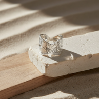 Anillo plateado cruzado con motivos circulares