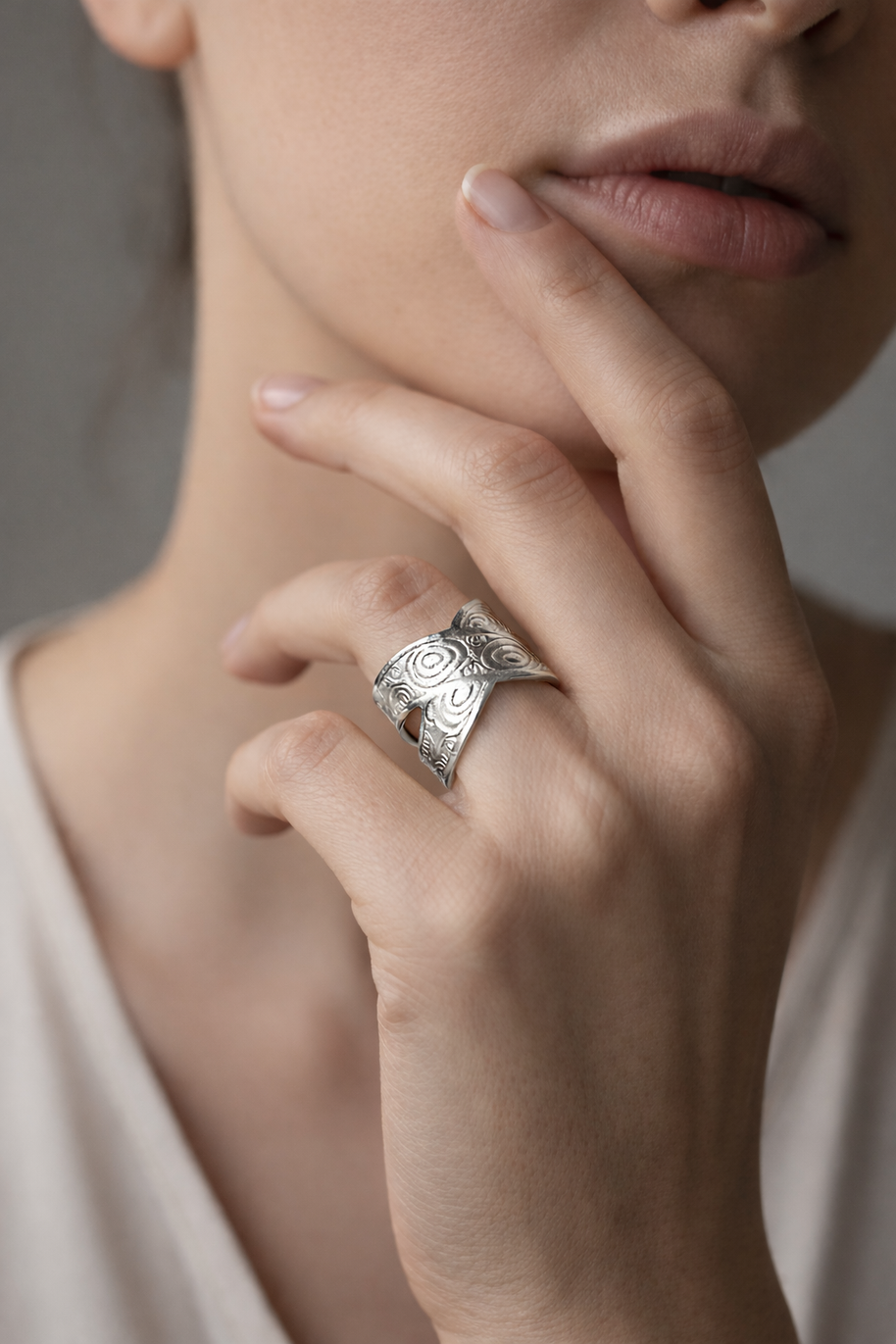 Anillo plateado cruzado con motivos circulares