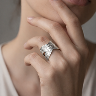 Anillo plateado cruzado con motivos circulares