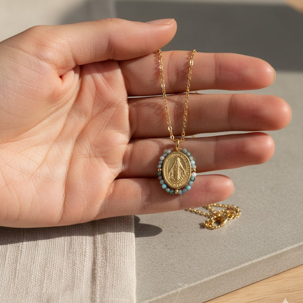 Collar dorado con medalla religiosa y cuentas