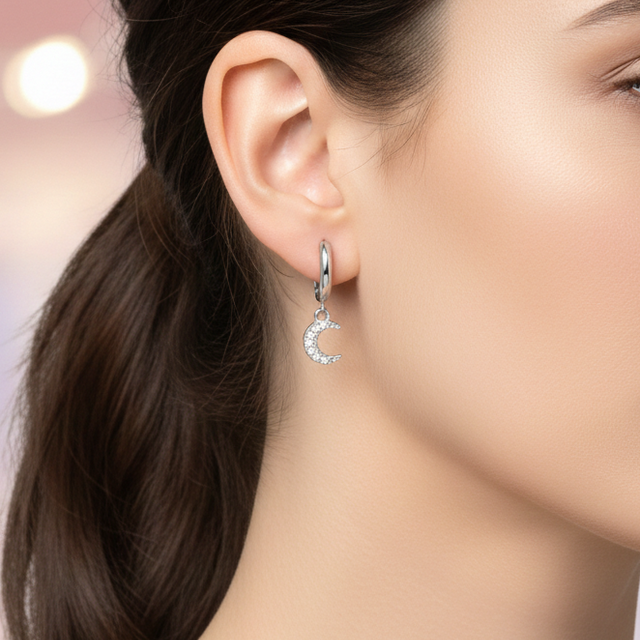 Mujer usando pendientes de aro plateados con colgante de luna Namare