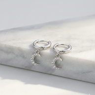 Pendientes de aros plateados con colgante luna de circonitas