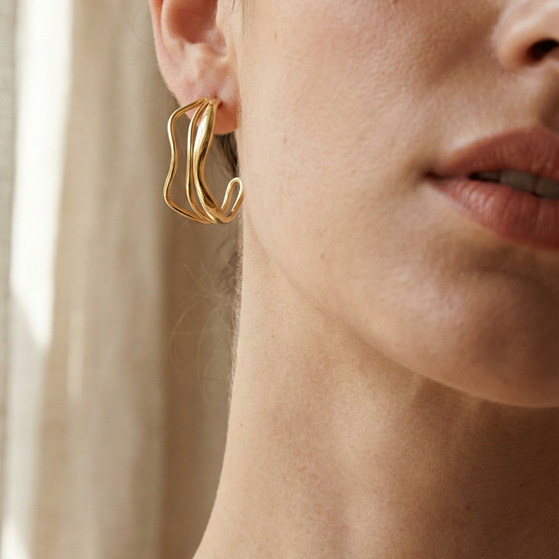 Pendientes de aros dorados con diseño ondulado y triple línea