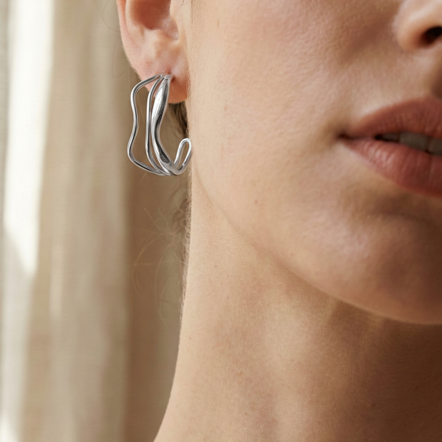 Pendientes de aros plateados con diseño ondulado y triple línea