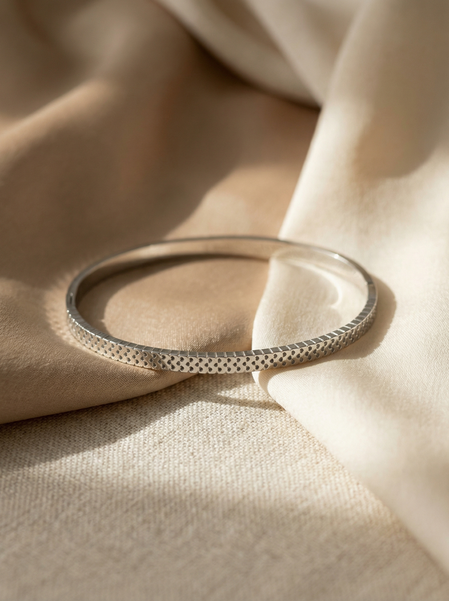 Pulsera rígida plateada tipo blazalete con borde dentado