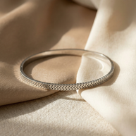 Pulsera rígida plateada tipo blazalete con borde dentado