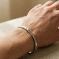 Pulsera rígida plateada tipo blazalete con borde dentado