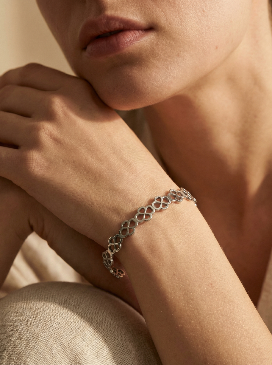 Pulsera rígida tipo brazalete plateado de aros de flores