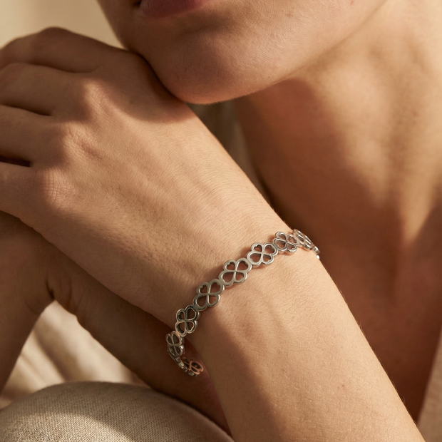 Pulsera rígida tipo brazalete plateado de aros de flores