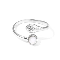 Anillo plateado con cabeza de serpiente y piedra.