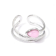 Anillo plateado con piedra rosa.