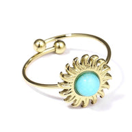 Anillo dorado ajustable con piedra en forma de sol de color turquesa.