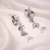 Pendientes plateados con colgantes de cola de pez