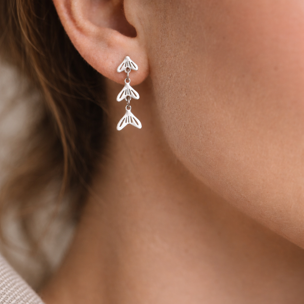 Pendientes plateados con colgantes de cola de pez