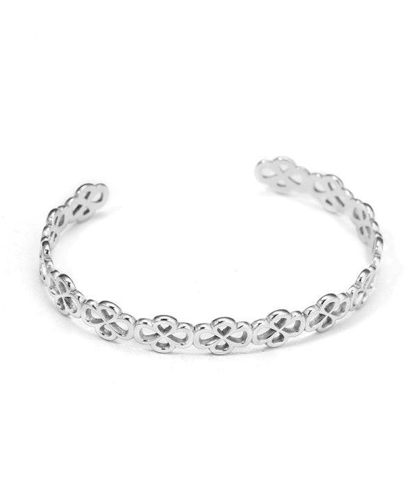 Pulsera rígida tipo brazalete plateado de aros de flores.